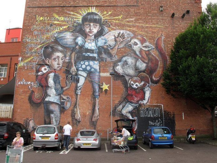 Children, monkeys and a dog pose in this huge street art painting by German graffiti artist Hera and Akut
