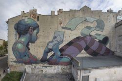 This enormous street art mural by graffiti artist Aryz shows a girl sitting in water reading a love letter
