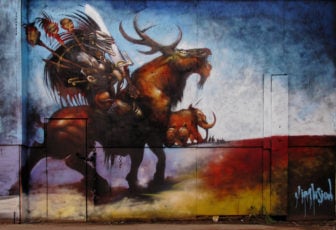 A fantasy warrior in an evil-looking helmet rides a horned beast in this graphic novel styled graffiti mural by artist Jim Vision