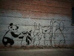 A panda can't paint his own back without a little help from his friends in this street art painting by Phil Lumbang