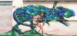 A warrior girl and her companion dinosaur are on high alert in this fantasy graffiti mural by street artist Probs