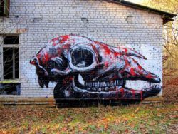 Street artist ROA paints a graffiti art work of a blood spattered animal skull as a reminder of animals that face extinction