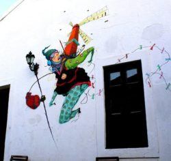 Street artists Grupo Acidum create a graffiti mural that allows this woman to fly with the help of a handy windmill