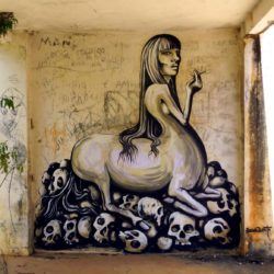 A centaur woman smokes a cigarette while perched on a pile of skulls in this social commentary painting by street artist Dinho Bento