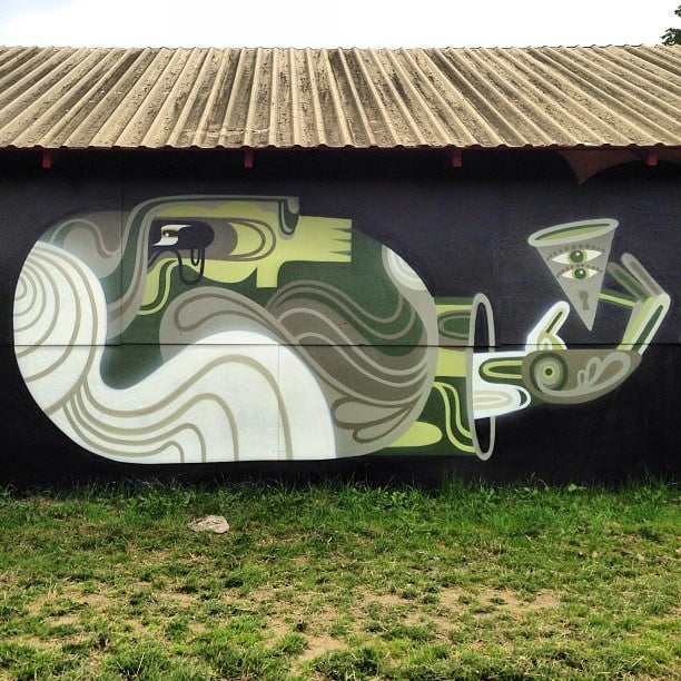 An olive color scheme gives this street art mural by Reka One a pensive and thoughtful mood
