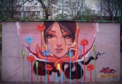 A beautiful girl exists in her own private space bubble in this portrait graffiti piece by Erase