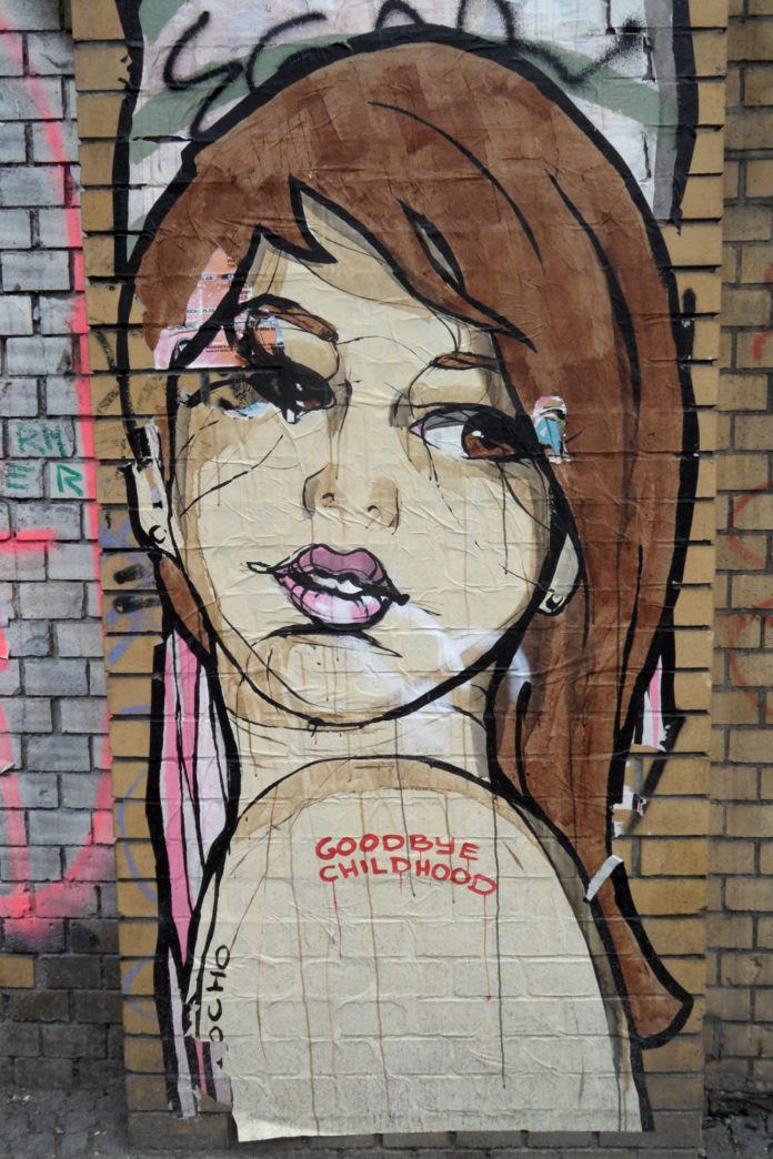 Graffiti artist El Bocho reflects the feeling of growing up in this paste up street art of a pretty girl looking over her shoulder