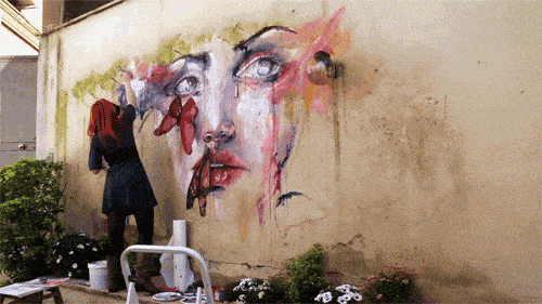 This animated graffiti GIF shows Agnes Cecile creating a beautiful street art portrait