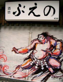 A bulky sumo wrestler wears Titi Freak's street art style in this mural on a garage door