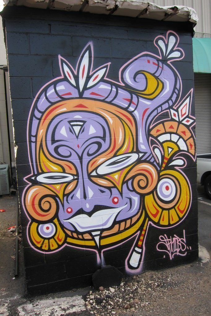 A forgotten wall gets a makeover by street artist Phibs with this tribal and cartoon portrait graffiti