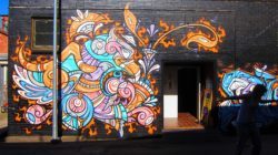 A happy Graffiti phoenix smiles at all who enter in this street art mural by Phibs