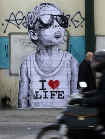 Street artist Stamatis expresses how much he loves life with this powerful poster graffiti art work that features a cheeky little boy