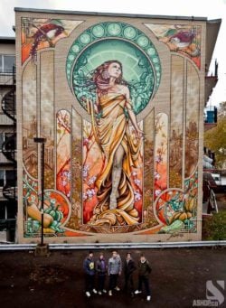 Ashop street artists celebrate the completion of their large scale mural of the Madonna in Montreal