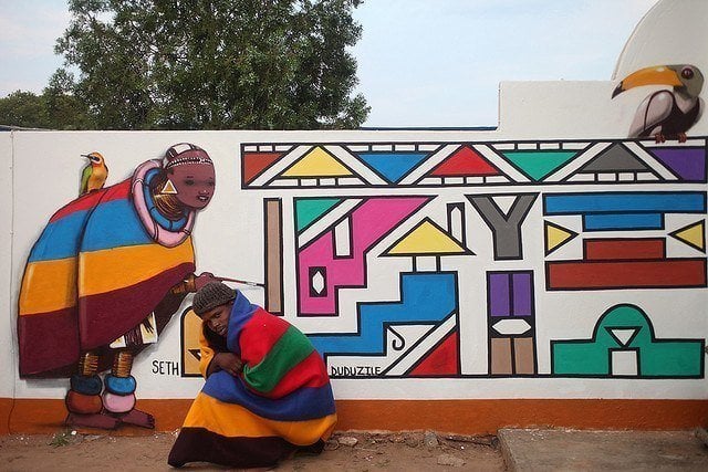 French graffiti muralist Seth collaborates with a local artist in South Africa to create a colorful African street art work