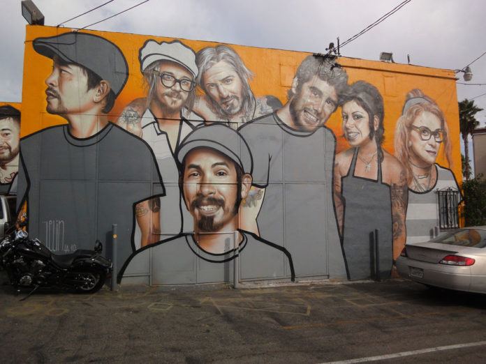 People pose for a party pic in this caricaturized graffiti mural by street artist Belin