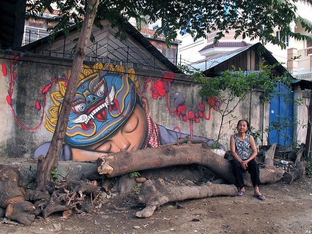 Seth AKA Globepainter creates a graffiti mural of a boy in traditional headdress in Colombia