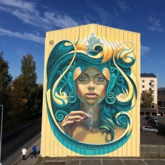 A beautiful woman holds a magic chrystal in this extra large street art mural in Finland by Wild Drawing