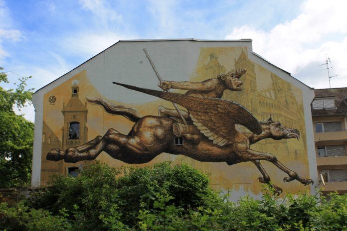 An adventurous monkey rides a flying horse in this street art mural in Germany by Wild Drawing
