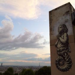 This large street art mural in Paris shows a hybrid child seahorse praying. Painting by Wild Drawing